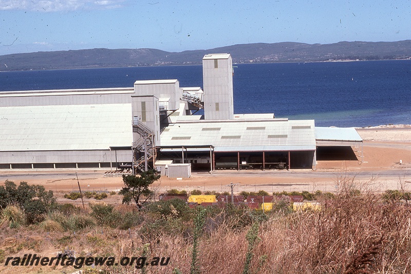 P19820
CBH grain facility, wheat bin, elevators, conveyors, carriage and loco shed, wagons in foreground, harbour in background, Albany, GSR line
