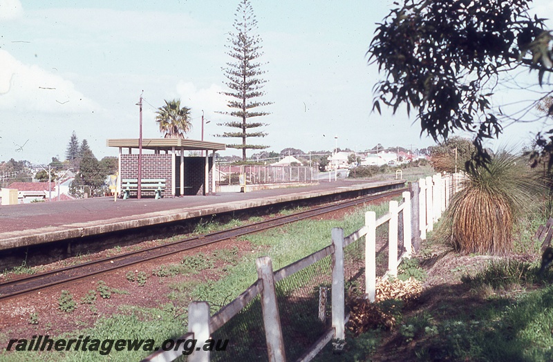 P19847
Platform, station shelter, track, white rail and post fence, Shenton Park, ER line, track level view
