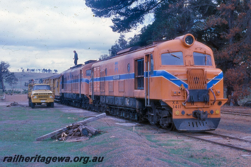 P19961
XA class 1411 in Westrail orange with blue and white stripe, another XA class loco, double heading goods train, truck, man on roof of loco, Asplin, DK line, side and front view
