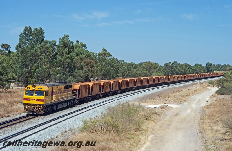 P21193
ARG Q class 4015 in the yellow with red stripe livery hauling a train of hopper wagons, Wattle Grove
