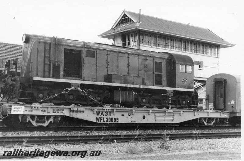 P21717
Former MRWA F class 40, loaded onto flat wagon WFL class 30059, part of eastbound  freight train, signal box, station building, Merredin, EGR line, end and side view
