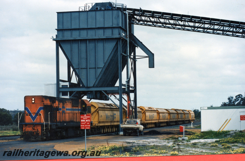 P21912
NA class 1871, on coal train, loading coal into Westrail hopper wagons from overhead coal tower, conveyor, trackside building, motor vehicle, Chicken Creek
