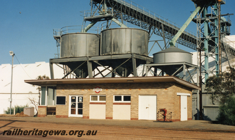 P21913
Station building, grain loading facility, wheat bins, conveyor, grain towers, Koorda, WLB line, view from track level
