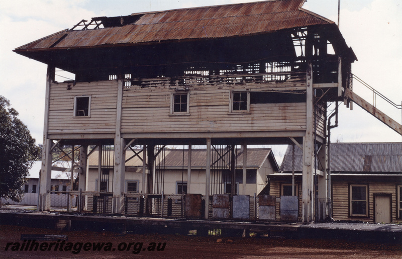 P21915
Signal box, gutted by fire, on stilts on platform, station buildings, Northam, ER line, side view from ground level
