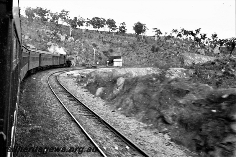 P21919
Steam hauled express train, on a bend approaching tunnel, signal, trackside building, Swan View, ER line, view from rear of train 
