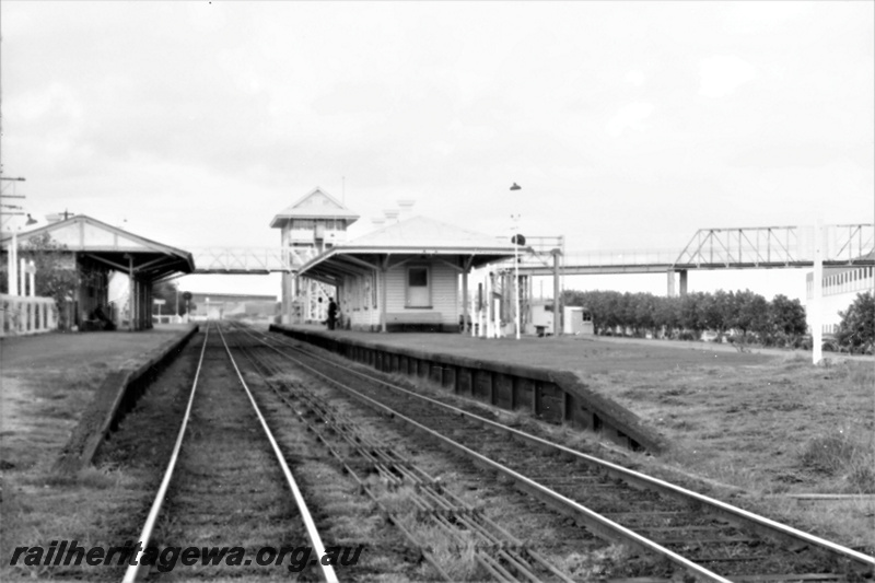 P21935
Station buildings, platforms, rodding, signal box, overhead footbridge, East Perth, ER line, view along the tracks towards the station
