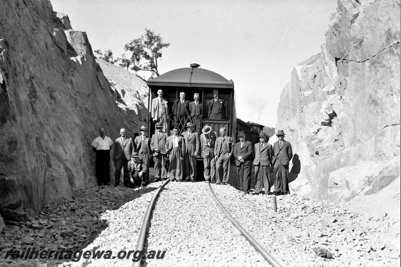 P21944
Group photo of 16 railway officials and workers, standing on the rear platform of a passenger carriage and on the track in the cutting, at the opening of the Swan View deviation, ER line, view from track level
