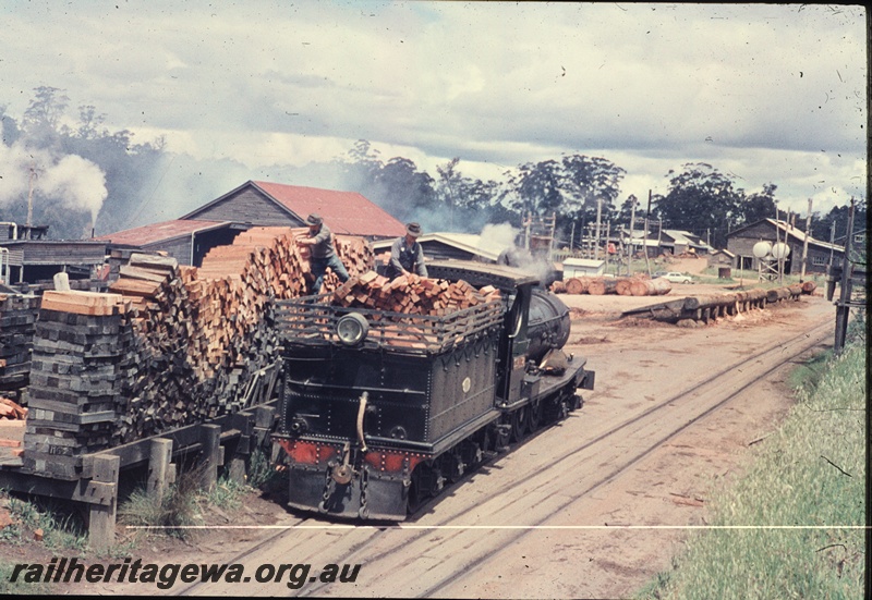 T04549
State Saw Mills loco SSM No. 2 steam locomotive  having its tender loaded with wood at a sawmill site.
