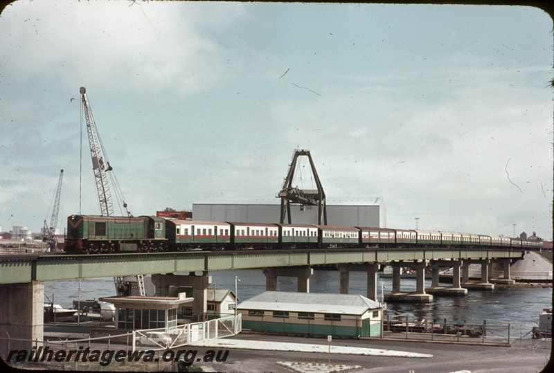 T04611
An unidentified R class diesel locomotive with side chains, hauling a special passenger train over the Fremantle bridge enroute to Perth. See T4596 and T4609.
