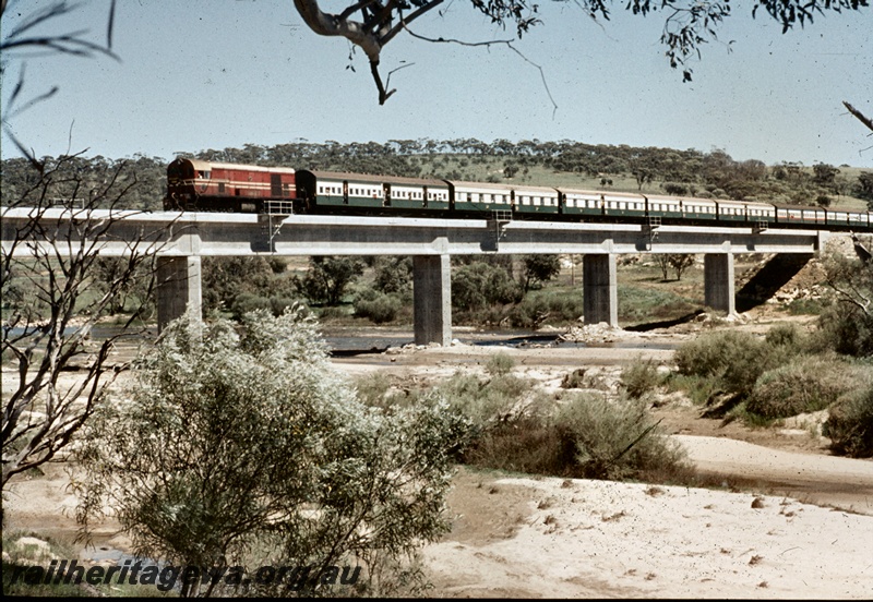 T04694
An unidentified F class diesel locomotive, painted in Midland Railway Co. colours, at the head of an ARHS Tour train traversing the Toodyay - Miling bridge over the Avon River.
