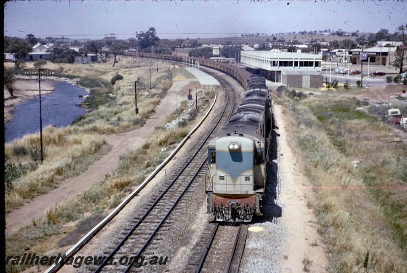 T04873
K class 201, with 3 other K class diesels, on a flint stone or iron ore train, platforms, station building, bracket signals, signal, carpark, river, Northam, ER line, view from elevated position, train coming towards camera
