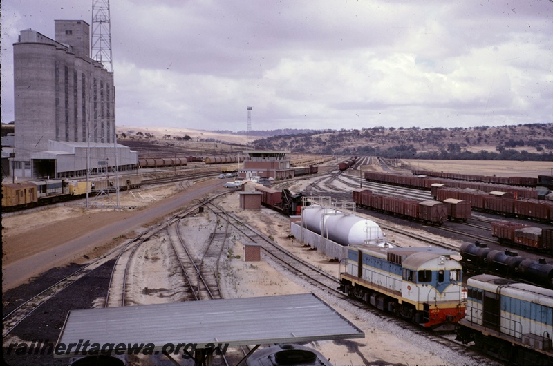 T05121
Overview of Avon Yard, J class 102, various locos, rakes of wagons, sidings, points, wheat silos, Yardmaster's Office , Northam, ER line
