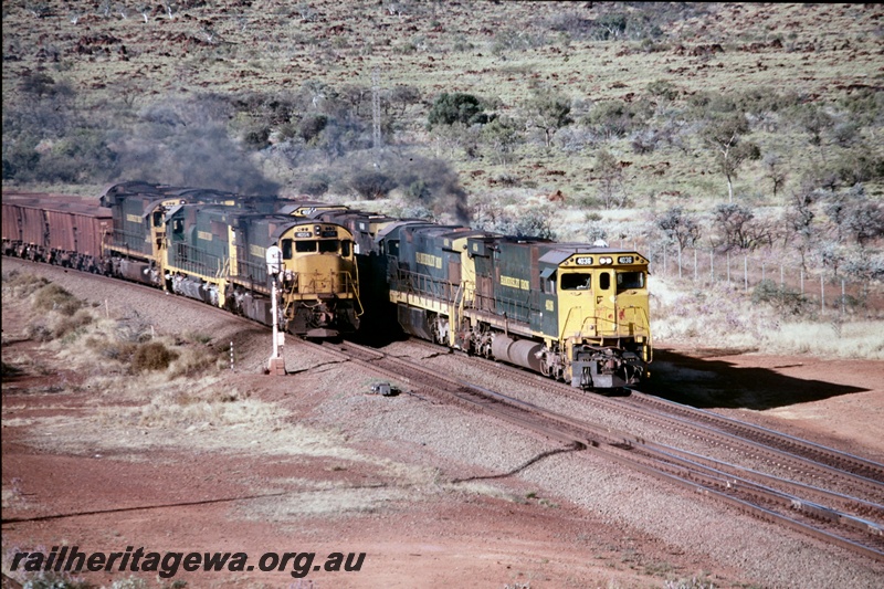 T05196
Hamersley Iron (HI) M636 class 4054 leads a triple headed iron ore train passing an ore train lead by M636R class 4036 at Tom Price.

