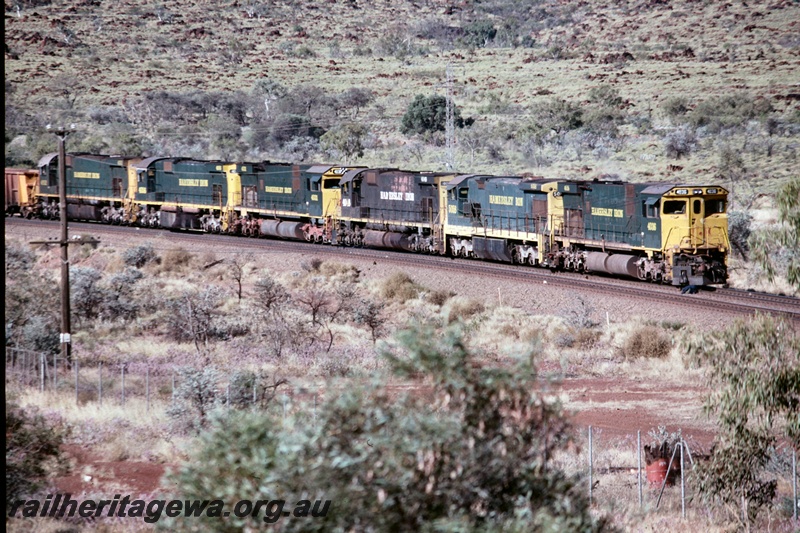 T05199
Hamersley Iron (HI) M636R class 4036, C36-7 class 5058, plus 4 unidentified locomotives haul a loaded iron ore train out of Tom Price.
