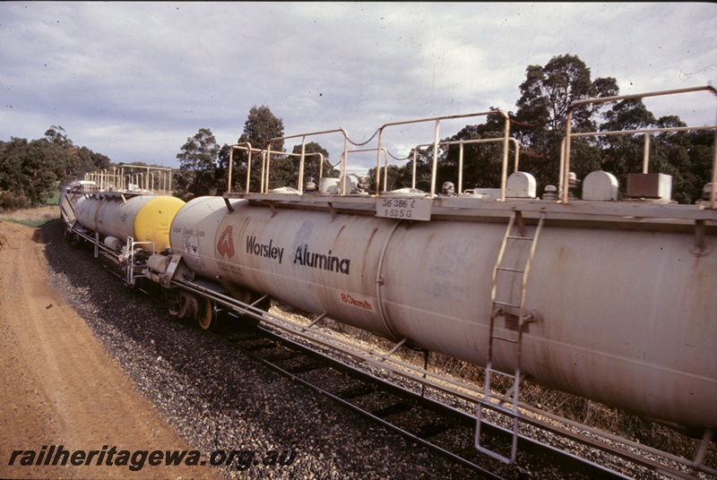 T05280
Worsley Alumina JK class tank wagon for the transport of liquid caustic soda, view along the track of wagons.
