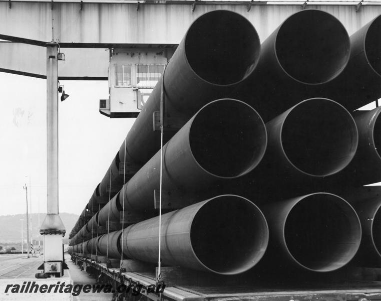 P00407
Bogie flat wagons loaded with pipes for the North West shelf gas pipeline, overhead gantry crane, Kewdale, view along the row of wagons.
