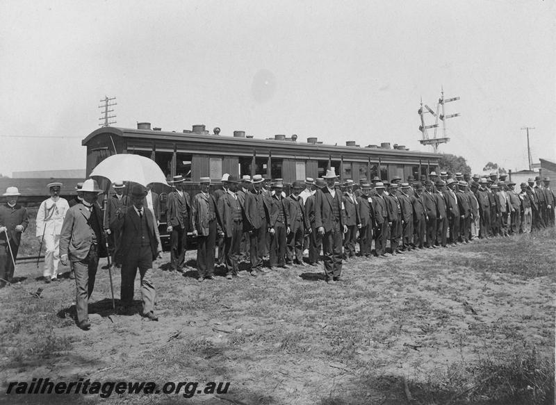 P00520
AA class carriage, men in civilian clothes lined up in ranks in front of the carriage. 
