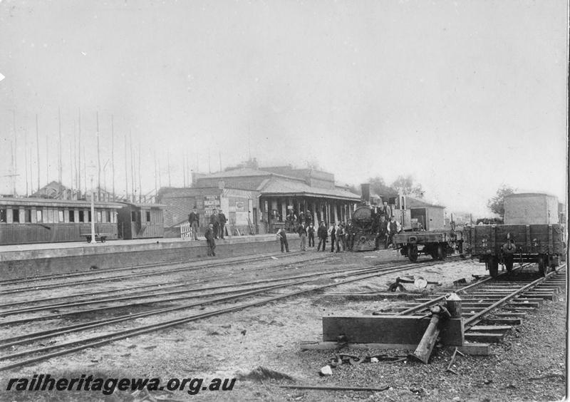 P00555
Station building, the first Perth station. I class loco in the yard, 6 wheel carriage and four wheel P class brakevan in the dock.
