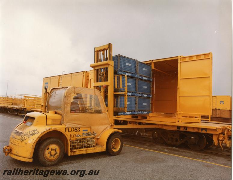 P00785
QUA class flat wagon with container, forklift, palletised loads being loaded into container
