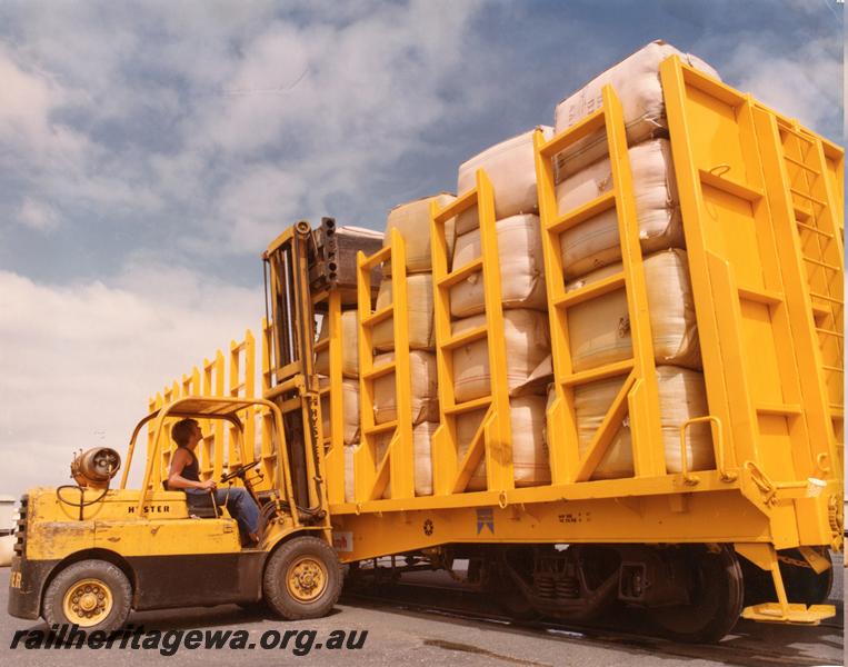 P00786
QUW class wool carrying flat wagon, being loaded by a forklift with wool bales
