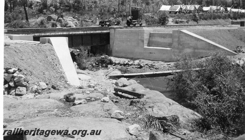 P01070
Steel girder bridge at 16m, 79 chain point on the ER line, under construction, workers tents in the background.
