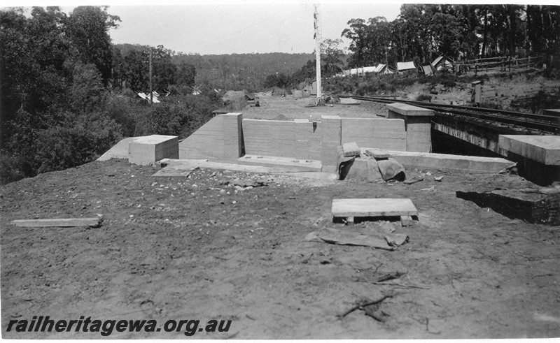 P01072
Steel girder bridge at 16m, 79 chain point on the ER line, under construction, view along the trackbed, workers tents in the background.
