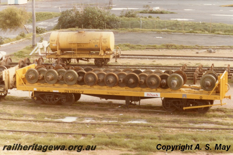 P01246
QV class 13345 wheel wagon loaded with wheel sets, side view, J class 1213 4-wheeled tanker, side view, yellow livery, North Fremantle, ER line.
