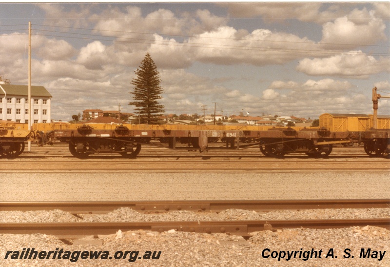 P01260
QRC class 6941 flat top container wagon, brown livery, side view, water column in the background, Leighton, ER line.
