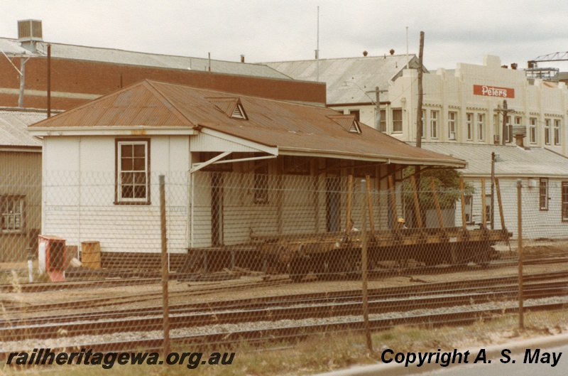 P01275
QBE class bogie bolster wagon, in front of a building at the west end of the carriage sheds, West Perth.
