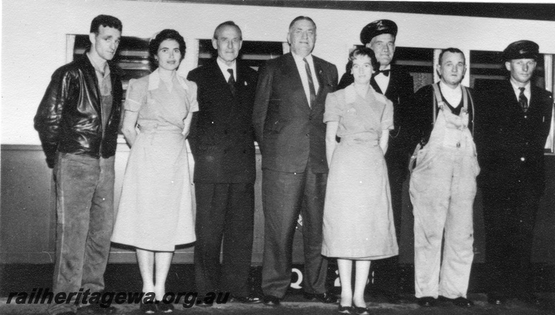 P01439
Commissioner of Railways, Mr. C. G. C. Wayne poses with a train crew in front of a carriage.
