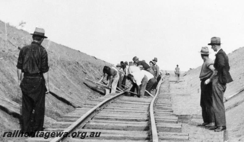 P01764
Track laying gang hand laying track in a cutting, view along the track.
