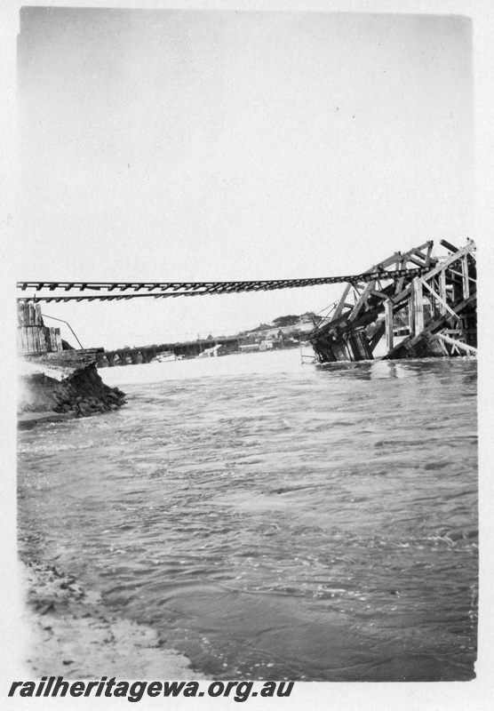 P01802
Collapsed bridge, North Fremantle, due to the 1926 flood, shows rails suspended and the collapsed trusses.
