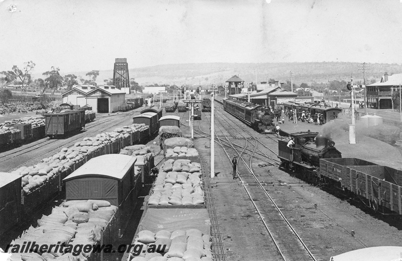 P01804
Station yard with loaded wagons, scissors crossover with double slip, station building, signal box, goods shed and the 50,000 gallon water tower, Northam, ER line, elevated overall view taken from the footbridge looking west,
