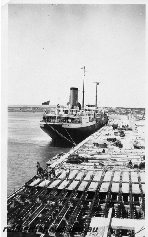P01960
Wharf, Geraldton, under construction, elevated view along the wharf, ship SS Amalthus berthed at the wharf.
