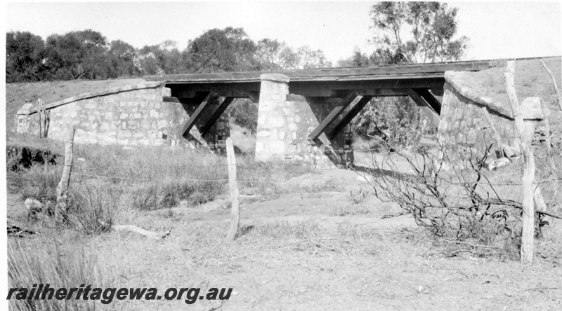 P01969
Timber bridge with masonry (stone) abutments and centre support, at the 28 mile 5 chain point from Geraldton on the GA line, side on view.
