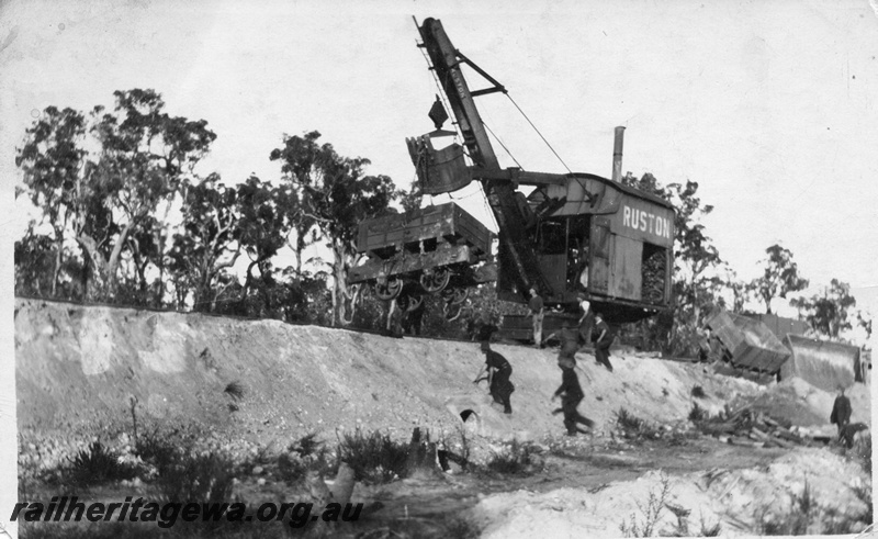 P02009
7 of 14. Ruston steam shovel righting derailed side tipping wagons on embankment, view of wagon suspended from shovel bucket, front and side view, construction of Denmark-Nornalup railway, D line.
