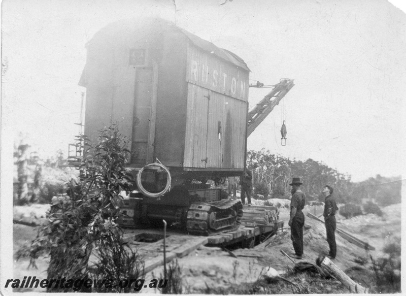 P02012
10 of 14. Ruston steam shovel being loaded onto a railway flat wagon with its bucket uncoupled from main boom cable, end and side view, construction of Denmark-Nornalup railway, D line.
