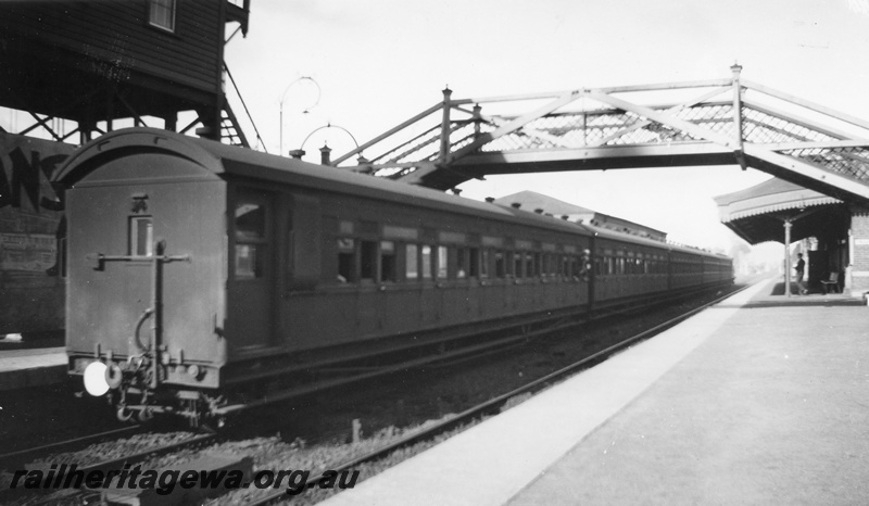 P02017
Suburban passenger carriages, end and side view, Guildford station, elevated signal box, pedestrian overbridge, looking east, ER line.
