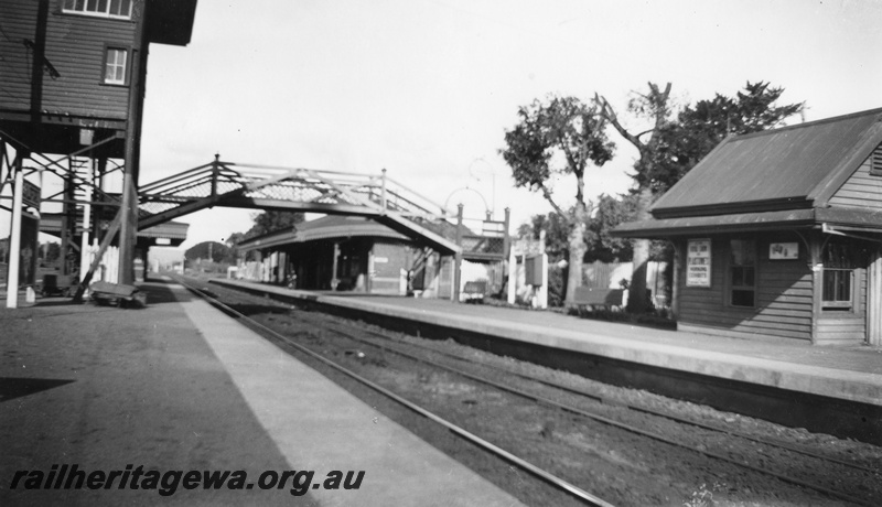 P02018
Station buildings, Guildford, elevated signal box, platform level signal box, pedestrian overbridge, platforms, nameboard, advertising billboard, looking west, ER line.
