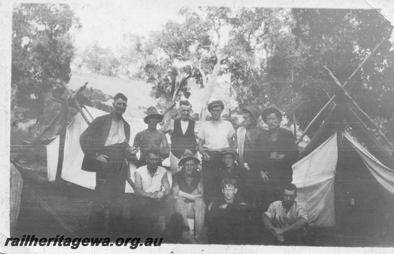 P02024
Construction workers, group photo with tents behind them
