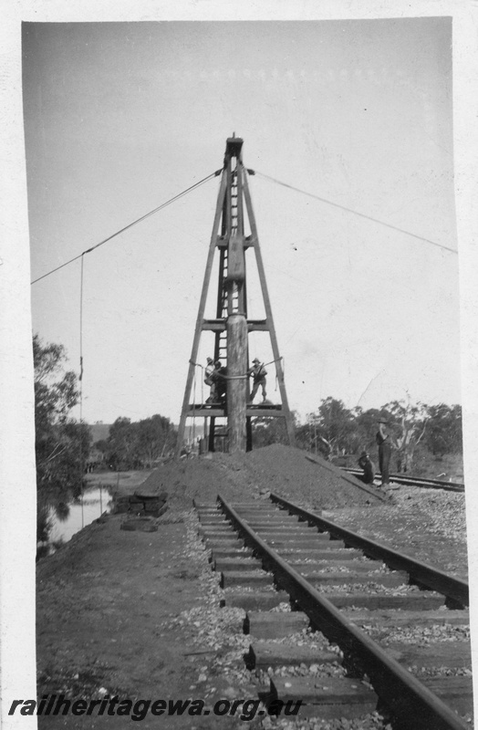P02060
Pile driving derrick on trestle bridge construction, newly ballasted adjacent line, view along the track, possibly Guildford.
