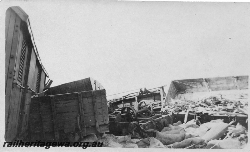 P02139
8 of 9 views of a derailment of No 26 Mixed on 26/6/1926 near Konnongorring, EM line, overall view of the derailed and smashed wagons with their contents spread around.
