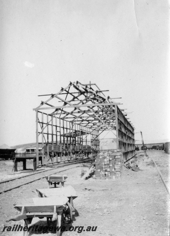 P02142
32 of 44 views of the construction of the railway at Esperance, CE line taken by Cedric Stewart, the resident WAGR engineer, large shed (goods shed?) under construction, end view, wooden wheelbarrows in foreground.
