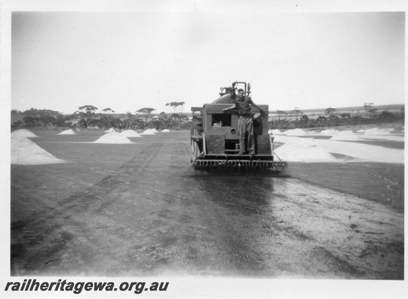 P02167
2 of 5 images of the construction of the dam at Duggan, WLG line showing the laying of bitumen on the catchment area and the covering of the area with sand
