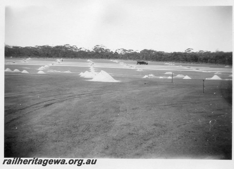 P02168
3 of 5 images of the construction of the dam at Duggan, WLG line showing the laying of bitumen on the catchment area and the covering of the area with sand
