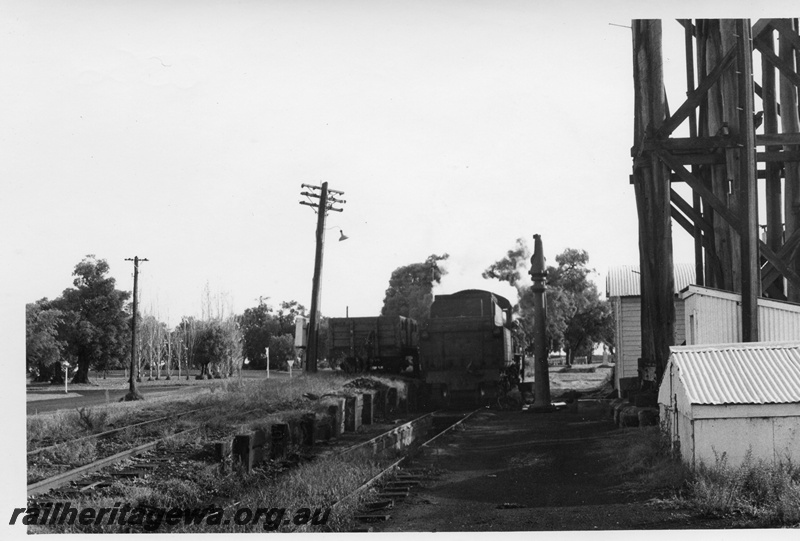 P02356
W class, wagon on the coaling ramp, water tower stand, water column, buildings, loco depot, Busselton, BB line, view along the track.
