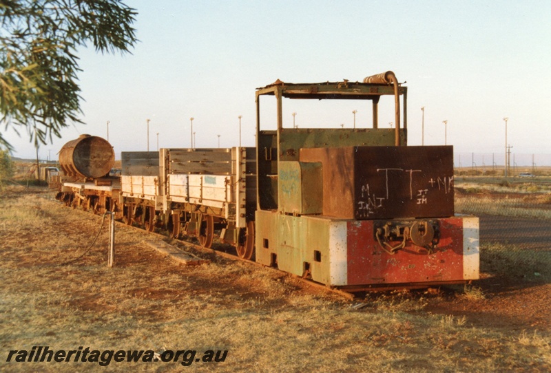 P02598
PWD loco PW24 with a string of wagons behind, Roebourne, side and front view, on display
