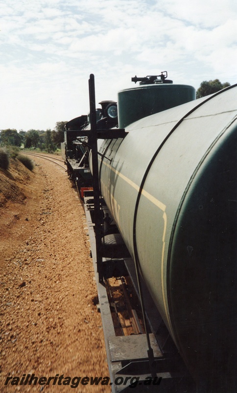 P02615
W class 908 running tender first between Wickepin and Yealering, NWM line, view looking along the tank wagon towards the loco taken from on the train
