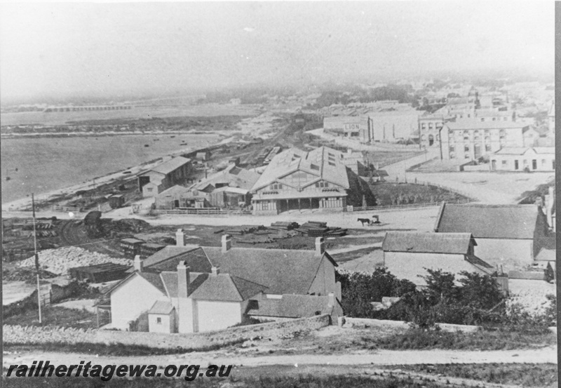 P02739
Fremantle railway station (original) looking east with old workshops on the left and goods shed. Picture taken after station roofed in 1887. Cliff St crossing in the middle of the photo. c1890.
