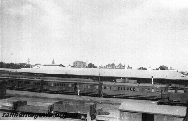 P02817
Kalgoorlie station platform, side view, dog box carriages, N class 4-4-4T steam locomotive, GC class wagon, van, low sided wagons, c1920s.
